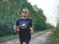 Hombre corriendo en un camino rural, con un bidón de agua en la mano. El antes y después de su entrenamiento.