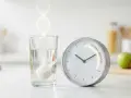 Un vaso de agua con una cucharada de polvo y un reloj marcan el momento en que la glicina rompe el ayuno.