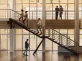 Personas subiendo escaleras, disfrutando de los beneficios de la actividad física en un moderno edificio de oficinas.