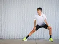 Corredor realiza estiramientos antes de correr, preparándose para su entrenamiento.