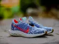 Zapatillas Nike Pegasus Plus hombre, con diseño tejido blanco y azul, detalles rojos y suela ZoomX.