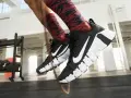 Pies con zapatillas Nike negras y calcetines rojos saltando la cuerda. La longitud de la cuerda de saltar es perfecta para el entrenamiento.