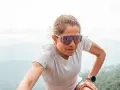 Mujer con gafas de correr, concentrada en su ascenso por la montaña.