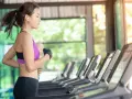 Mujer corriendo en cinta, parte de su rutina de ejercicios para perder peso.