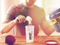 Hombre preparando su batido post-entreno. Es bueno tomar BCAA para la recuperación muscular.