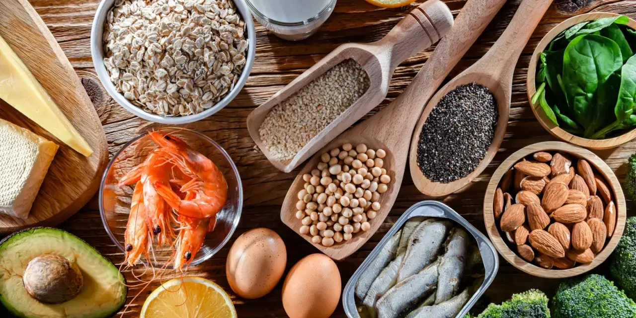 Variedad de alimentos con calcio: avena, leche, queso, camarones, huevos, almendras, sardinas, brócoli, espinacas, semillas de chía y sésamo.