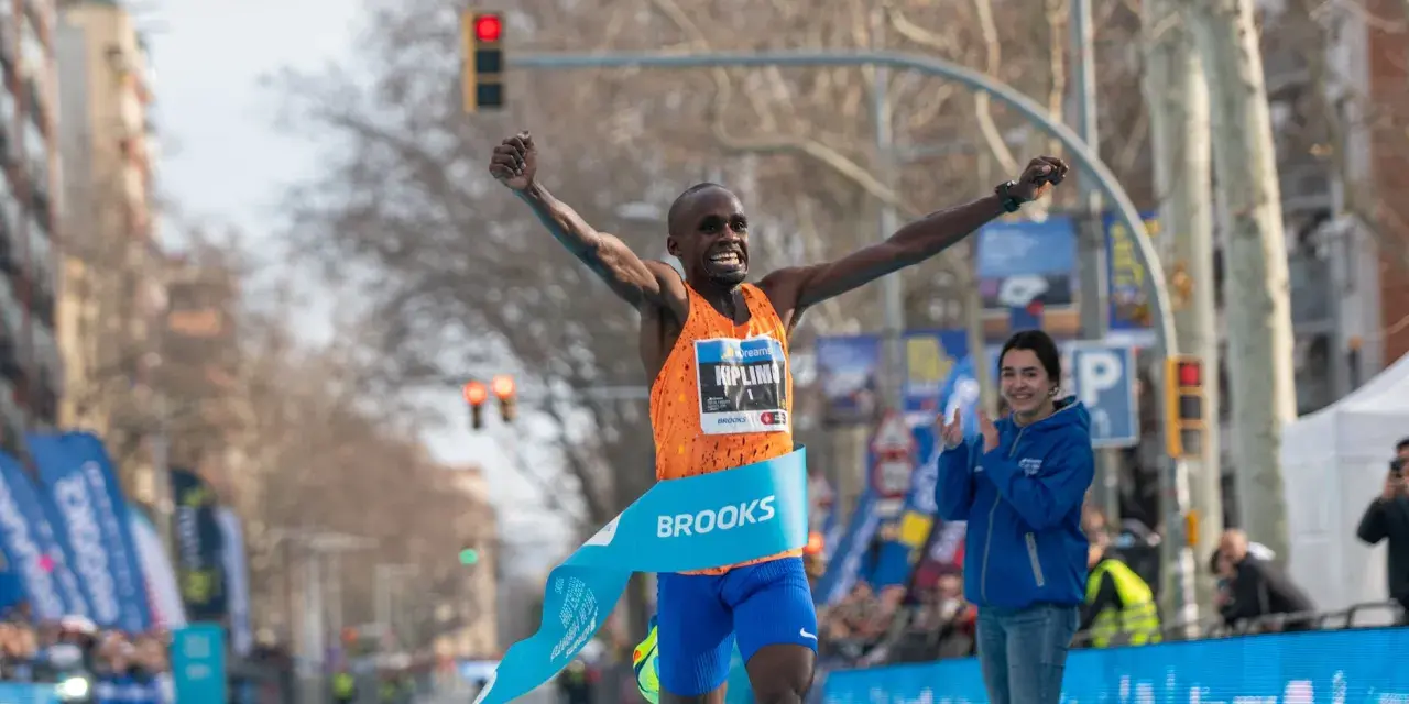 Ganador cruza la meta de la media maratón con los brazos en alto. ¡Un tiempo espectacular de 00:56:42!