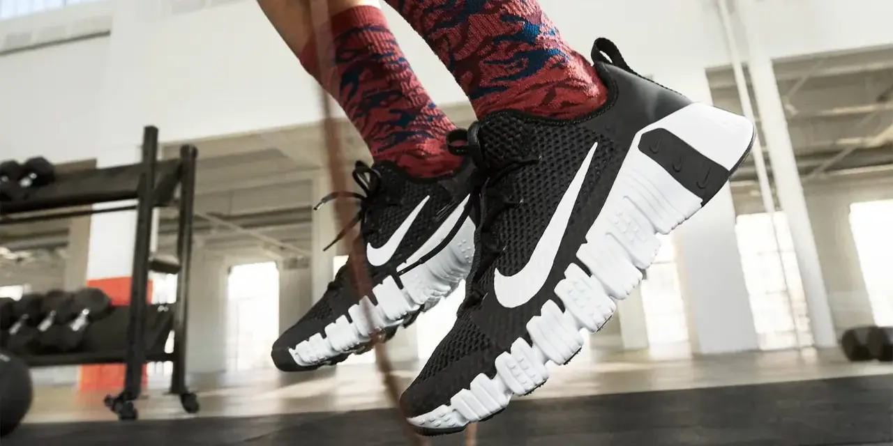 Pies con zapatillas Nike negras y calcetines rojos saltando la cuerda. La longitud de la cuerda de saltar es perfecta para el entrenamiento.