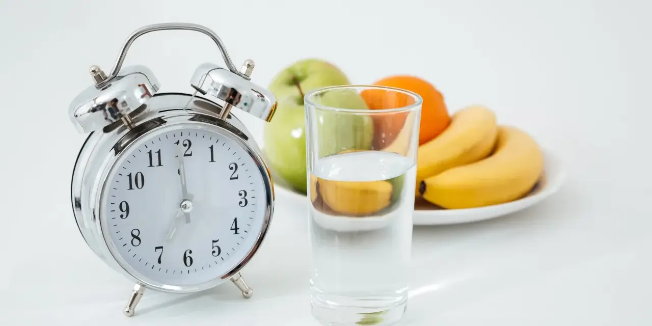 Reloj y vaso de agua, listos para un ayuno prolongado. ¿Qué tomar? Solo agua.