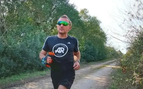 Hombre corriendo en un camino rural, con un bidón de agua en la mano. El antes y después de su entrenamiento.
