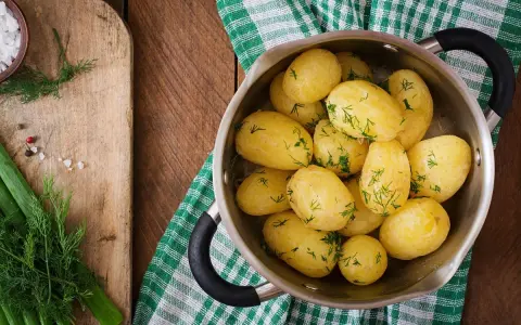 Patatas cocidas con eneldo en una olla, listas para disfrutar. Un plato sencillo y nutritivo, con pocas kcal patata cocida.