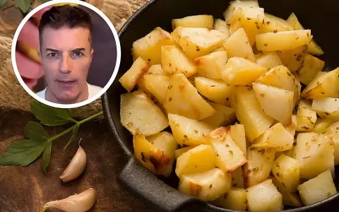 Un hombre mira patatas asadas. El índice glucémico de la patata cocida es un tema de interés.