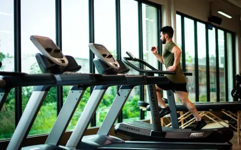 Hombre corriendo en cinta. ¿Qué es mejor bici estática o cinta de correr? La cinta ofrece un entrenamiento más completo.