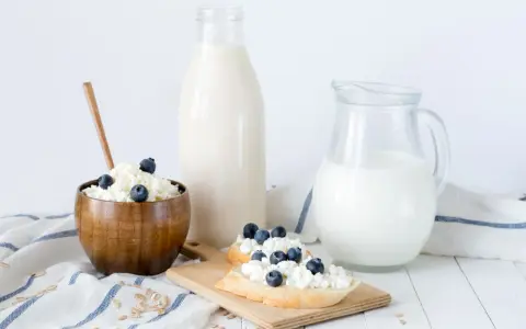 Desayuno saludable: requesón con arándanos, pan y leche. La caseína es una proteína láctea.