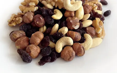 Montón de frutos secos variados: nueces, avellanas, anacardos y pasas. Parecen listos para engordar los frutos secos por la noche.