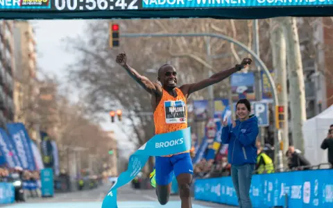 Ganador cruza la meta de la media maratón con los brazos en alto. ¡Un tiempo espectacular de 00:56:42!