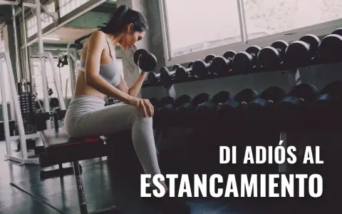 Mujer levanta pesas en gimnasio, aplicando sobrecarga progresiva para superar el estancamiento.
