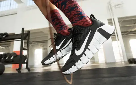 Pies con zapatillas Nike negras y calcetines rojos saltando la cuerda. La longitud de la cuerda de saltar es perfecta para el entrenamiento.