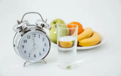 Reloj y vaso de agua, listos para un ayuno prolongado. ¿Qué tomar? Solo agua.