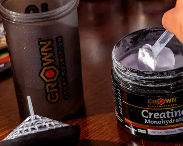 Un corredor prepara su batido con creatina monohidratada Crown Sport Nutrition para potenciar su rendimiento.