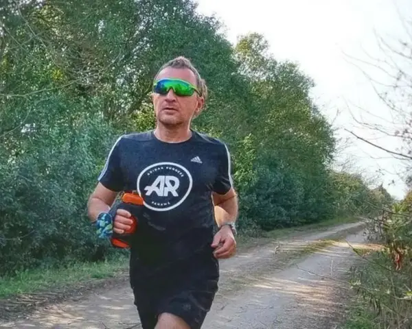 Hombre corriendo en un camino rural, con un bidón de agua en la mano. El antes y después de su entrenamiento.