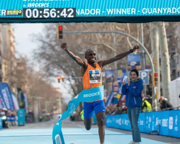 Ganador cruza la meta de la media maratón con los brazos en alto. ¡Un tiempo espectacular de 00:56:42!