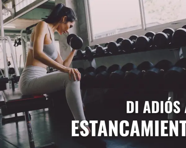 Mujer levanta pesas en gimnasio, aplicando sobrecarga progresiva para superar el estancamiento.