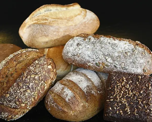 Variedad de panes artesanales, algunos con semillas. ¿Cuál es el pan más sano? Los integrales y con semillas suelen ser la mejor opción.
