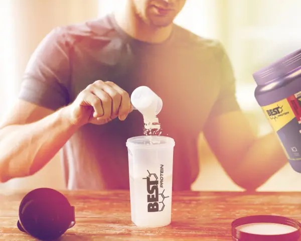 Hombre preparando su batido post-entreno. Es bueno tomar BCAA para la recuperación muscular.