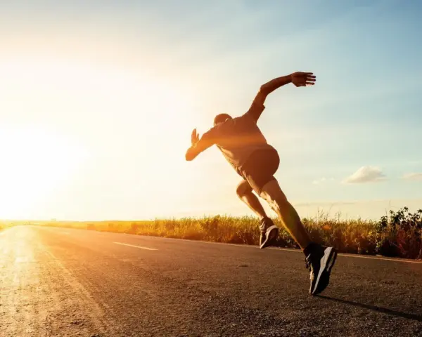 Corredor en una carretera al atardecer, experimentando lo que es un tempo run: un esfuerzo sostenido y desafiante.