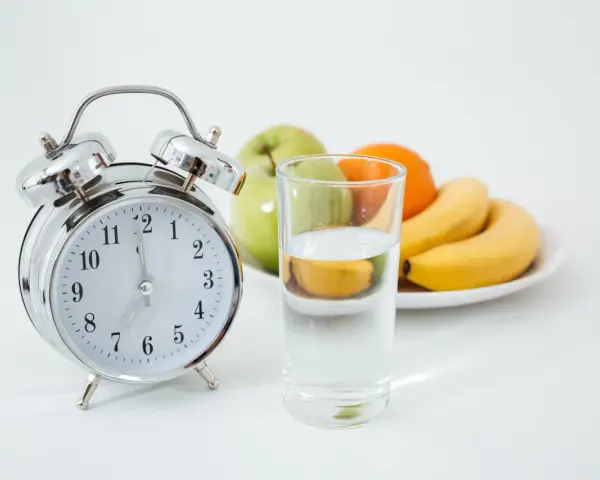 Reloj y vaso de agua, listos para un ayuno prolongado. ¿Qué tomar? Solo agua.