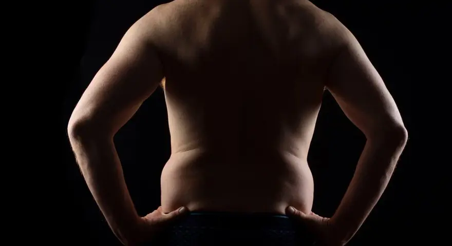 Espalda de hombre con manos en la cintura, mostrando su figura. ¿Será el resultado de un ayuno 72 horas?