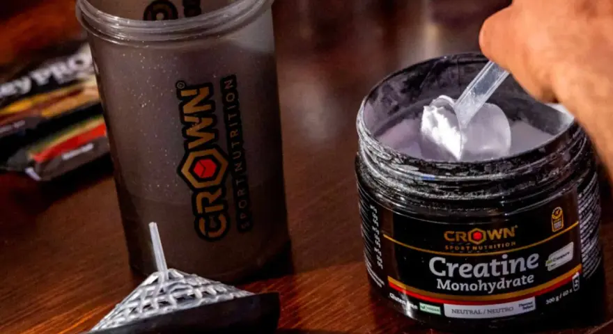 Un corredor prepara su batido con creatina monohidratada Crown Sport Nutrition para potenciar su rendimiento.
