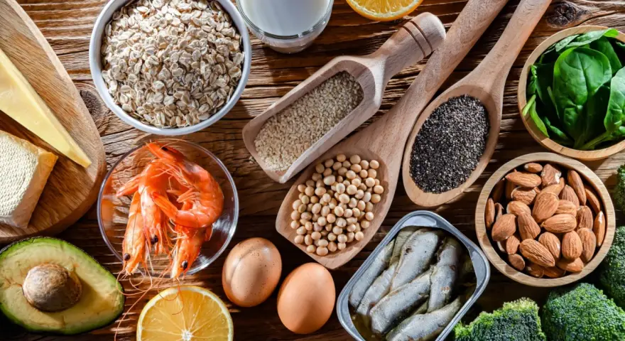 Variedad de alimentos con calcio: avena, leche, queso, camarones, huevos, almendras, sardinas, brócoli, espinacas, semillas de chía y sésamo.