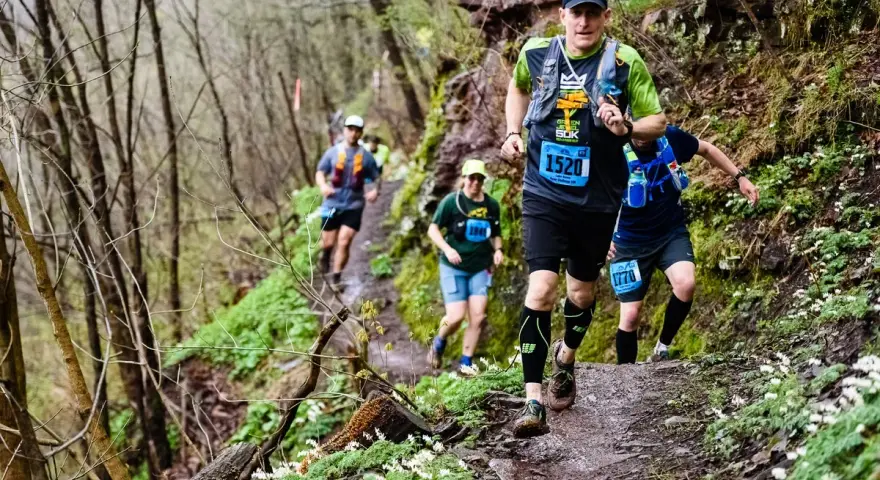 Corredores en un sendero boscoso, demostrando la resistencia necesaria para los ejercicios de fuerza para trail running.