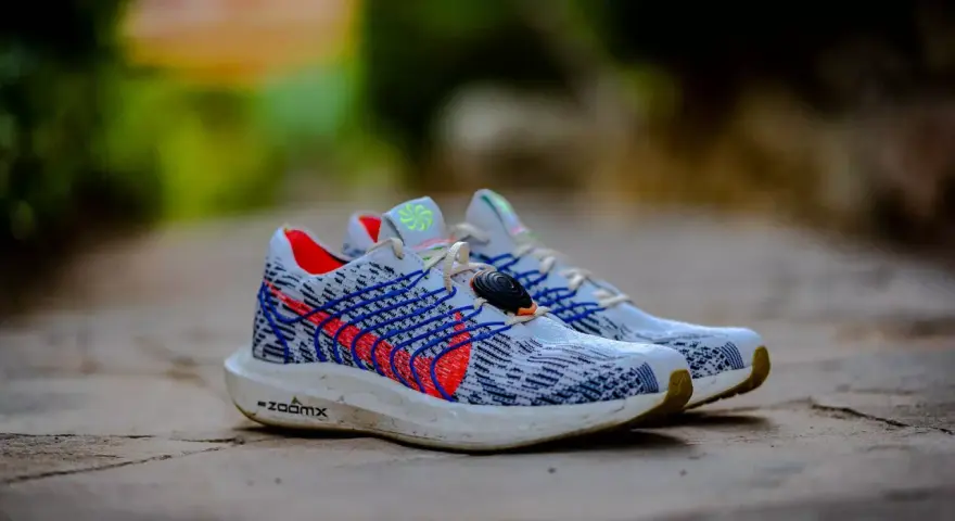 Zapatillas Nike Pegasus Plus hombre, con diseño tejido blanco y azul, detalles rojos y suela ZoomX.