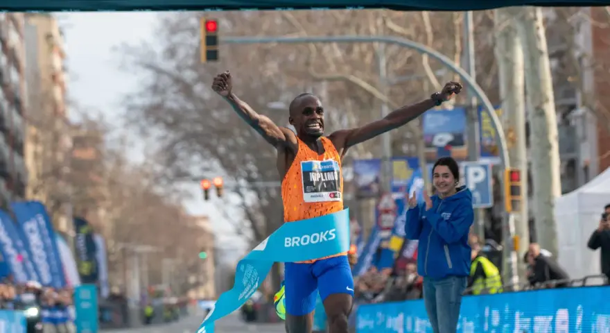 Ganador cruza la meta de la media maratón con los brazos en alto. ¡Un tiempo espectacular de 00:56:42!