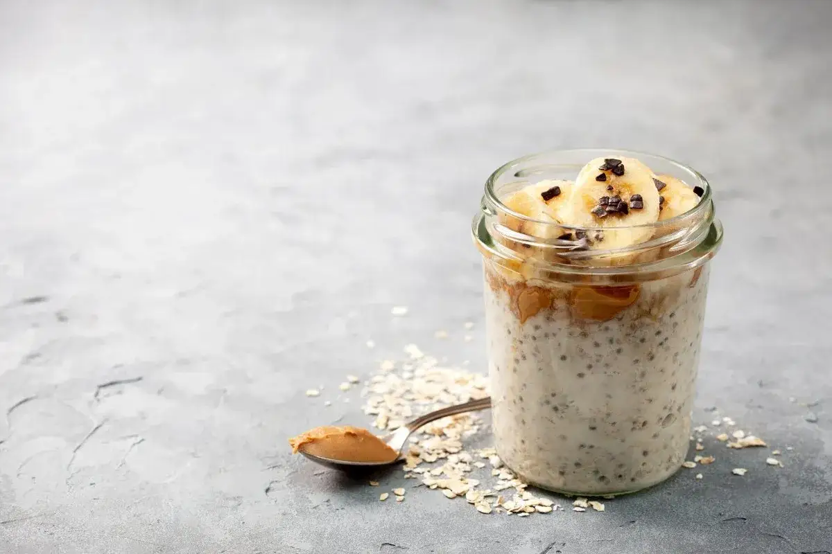 Avena nocturna en un frasco con plátano y mantequilla de maní. Descubre los beneficios de la avena por la noche.
