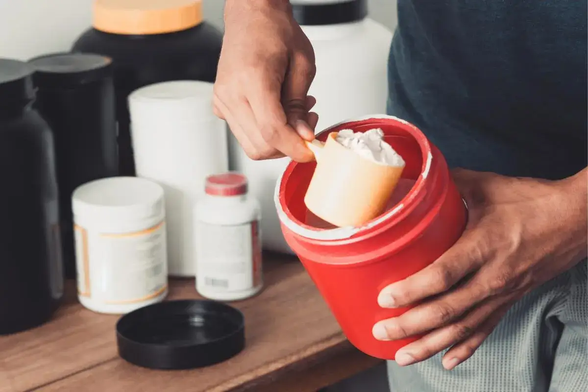 Hombre preparando un batido con suplementos. Si bien la creatina engorda, es un gran aliado para ganar masa muscular.
