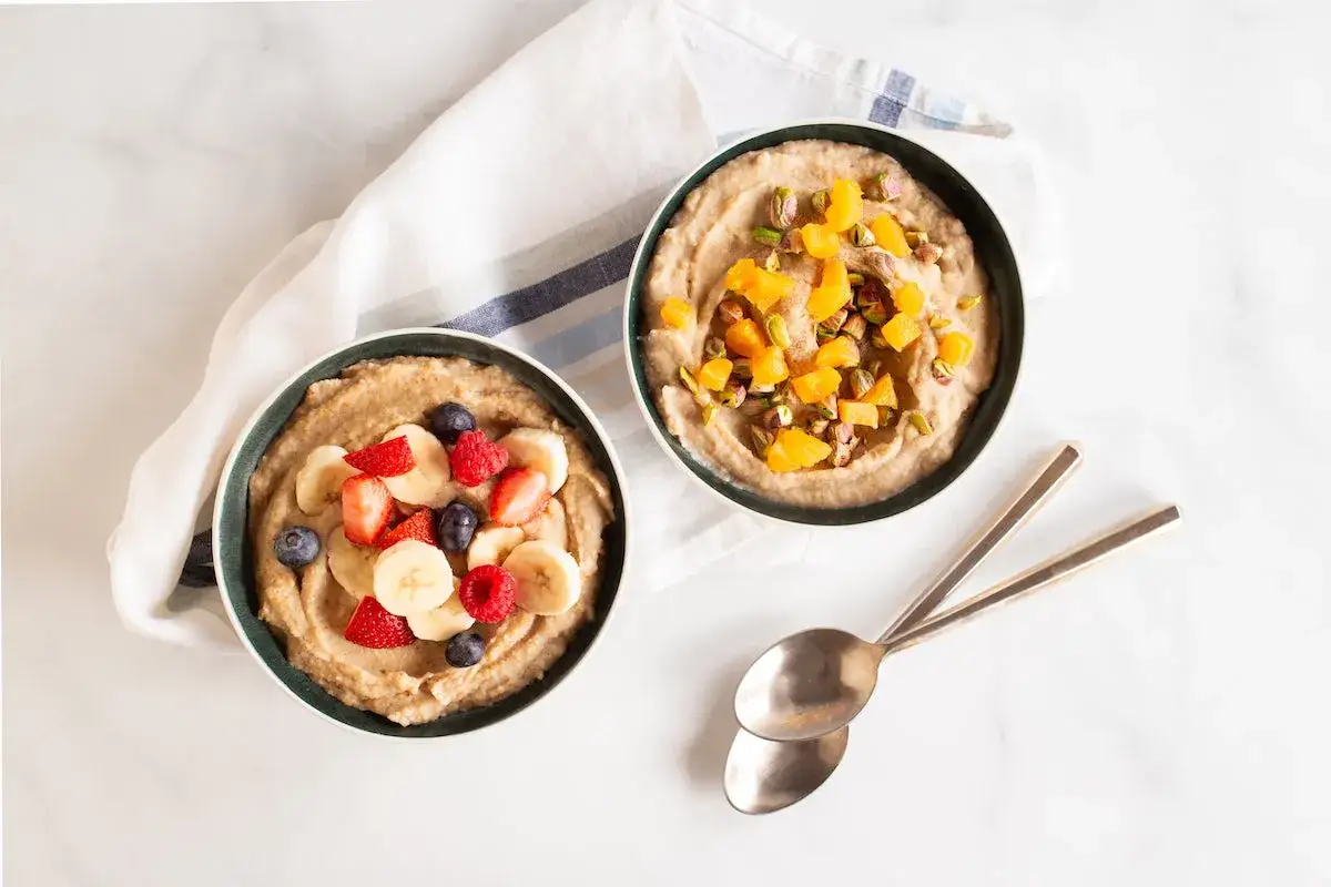 Dos tazones de crema de arroz, uno con frutas y otro con pistachos y albaricoques. &iexcl;Cuidado, la crema de arroz engorda si no se consume con moderaci&oacute;n!