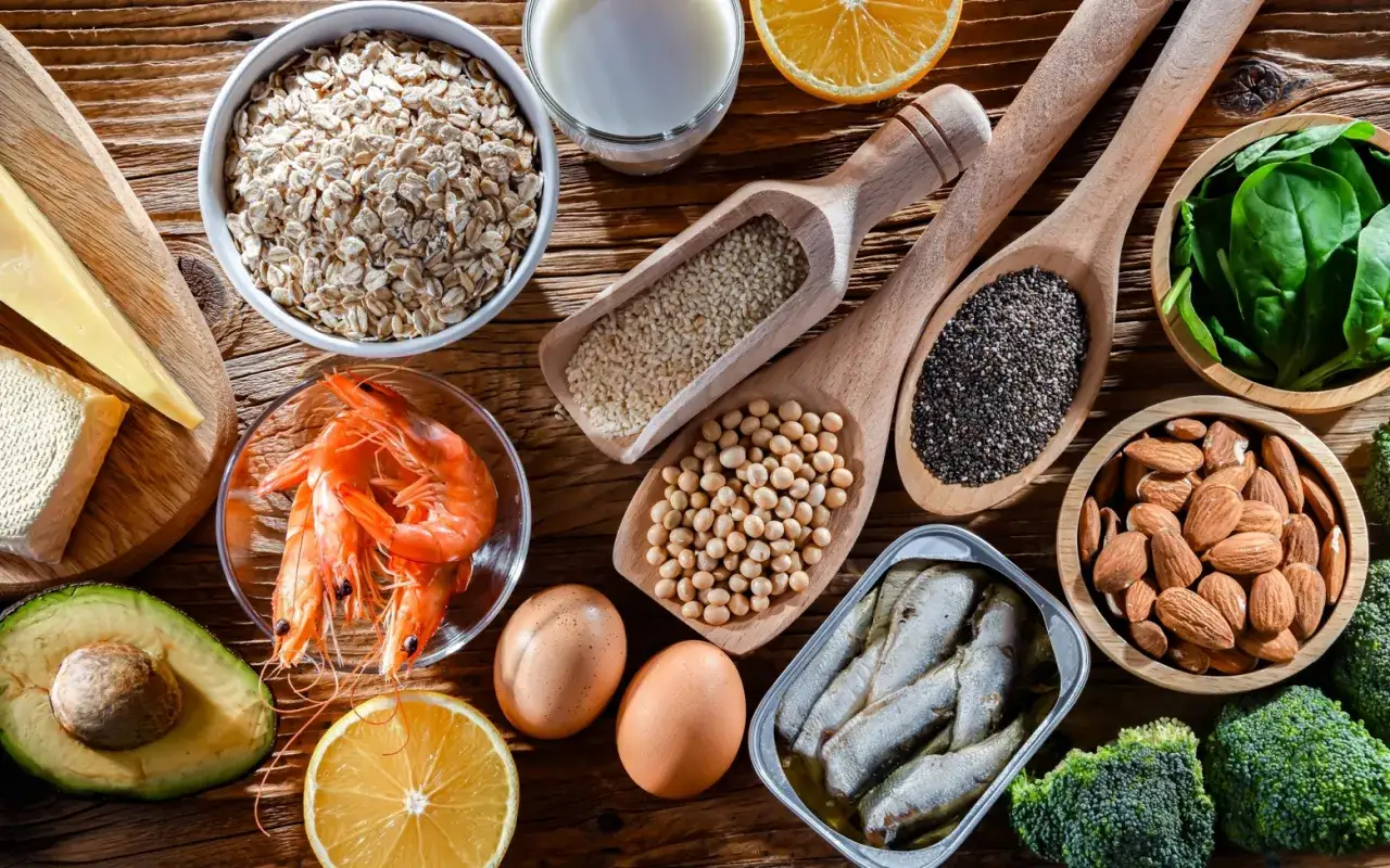 Variedad de alimentos con calcio: avena, leche, queso, camarones, huevos, aguacate, naranjas, espinacas, almendras, brócoli, sardinas, semillas de chía y sésamo.