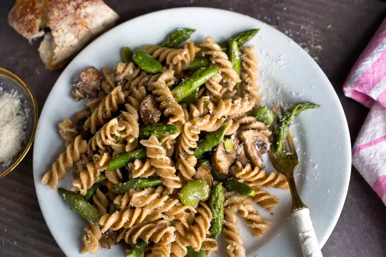Plato de pasta integral con esp&aacute;rragos y champi&ntilde;ones. Aunque la pasta integral engorda, esta versi&oacute;n saludable se ve deliciosa.