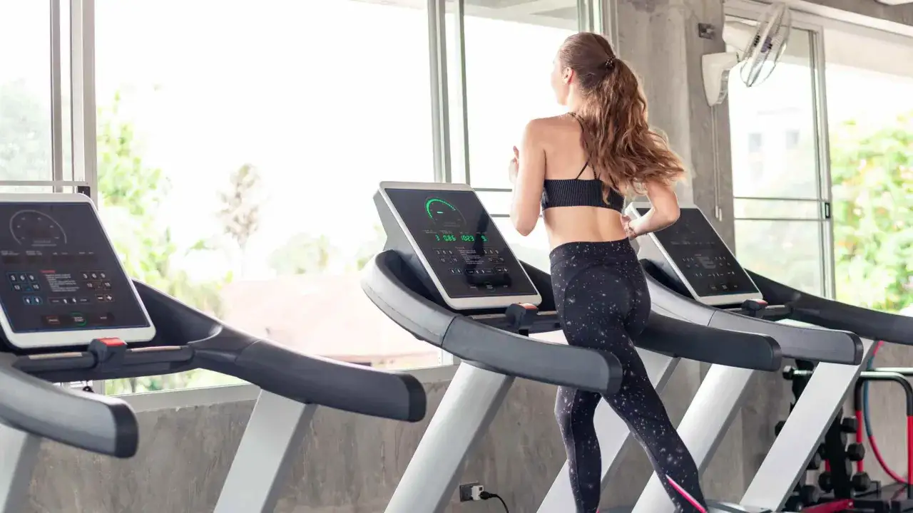 Mujer corriendo en cinta. &iquest;Qu&eacute; es mejor bici est&aacute;tica o cinta de correr? La cinta ofrece un entrenamiento cardiovascular completo.