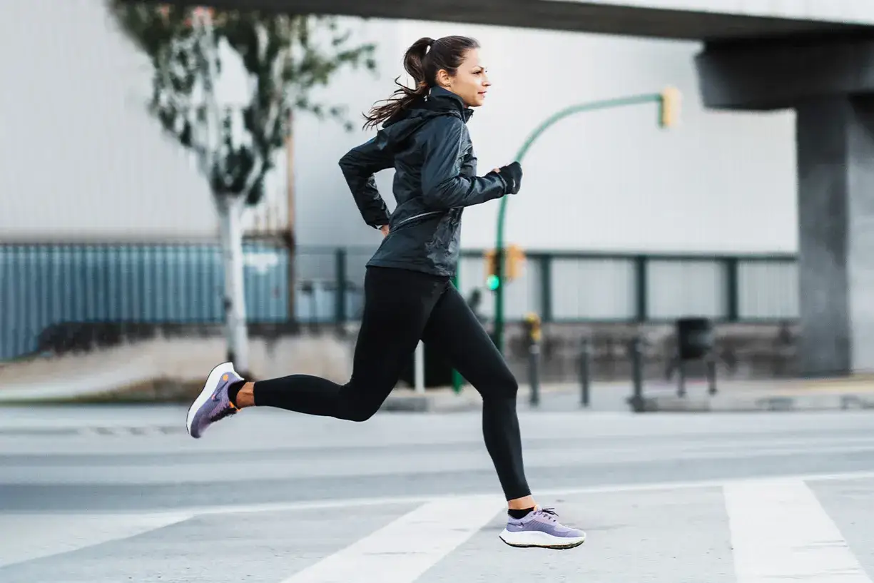 Mujer corriendo en la calle, concentrada en c&oacute;mo respirar al correr para mejorar su rendimiento.