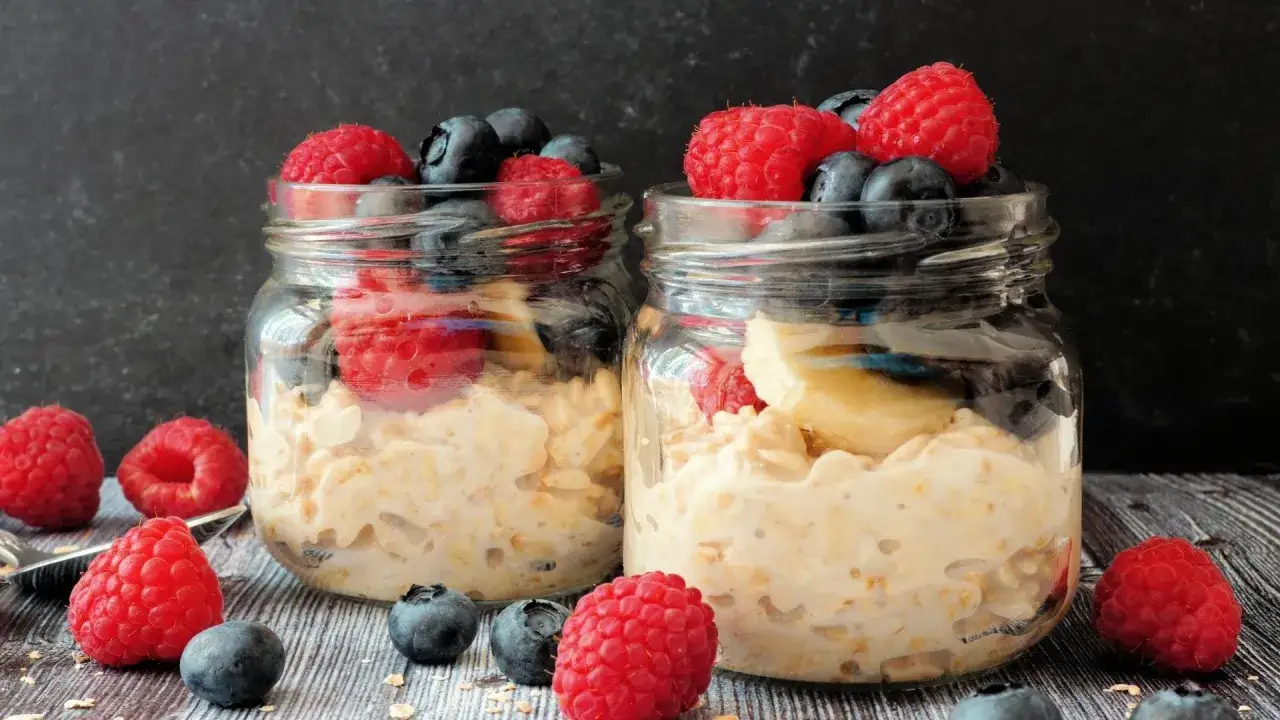 Dos frascos con avena y frutas rojas y azules, perfectos para postres saludables recetas.