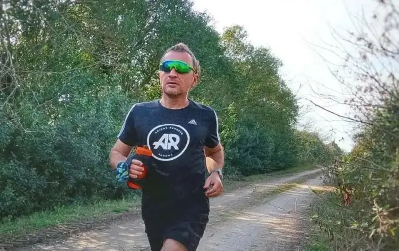 Hombre corriendo en un camino rural, con un bidón de agua en la mano. El antes y después de su entrenamiento.