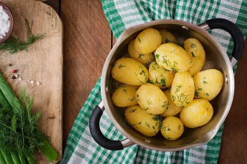 Patatas cocidas con eneldo en una olla, listas para disfrutar. Un plato sencillo y nutritivo, con pocas kcal patata cocida.